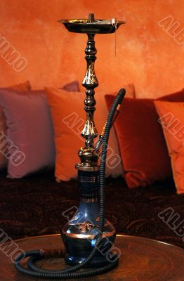 A hookah on a background of a red wall