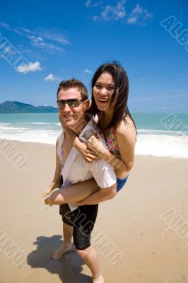 hunk carrying woman piggyback style ath beach