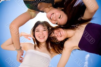three happy girl friends looking down
