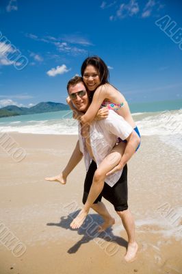 hunk carrying woman piggyback style ath beach