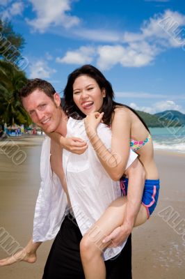 happy playful couple at the beach