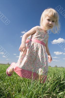 happy little girl on green meadow