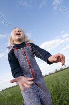 happy little girl on green meadow