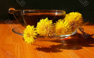 Bouquet of dandelions and cup of tea