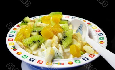 Fruit salad in a plate on a black background