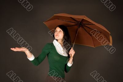 Girl with umbrella checking for rain