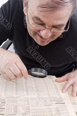 Senior read newspaper with magnifying glass