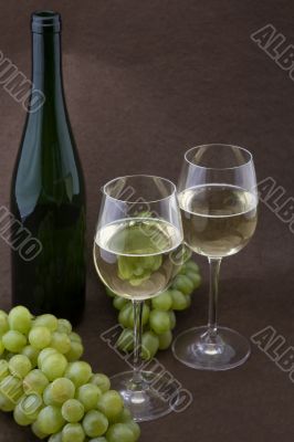 White wine with bottle, glasses and grapes