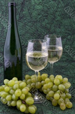 White wine with bottle, glasses and grapes