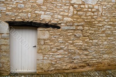 Old yellow stone wall with white door