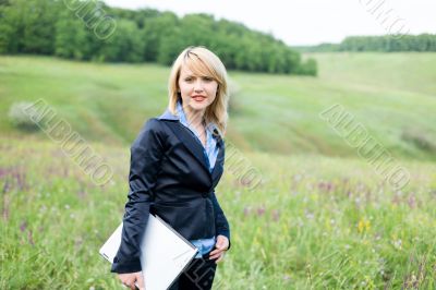 Girl with laptop stay on meadow