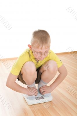 Boy measures weight on floor scales