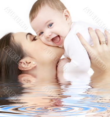 laughing baby playing with mother in water