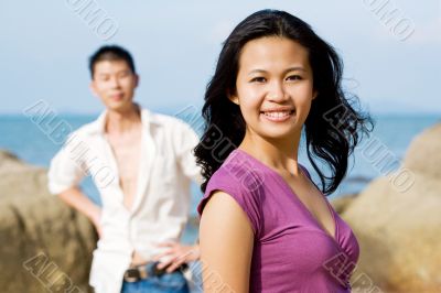 young couple standing by the beach