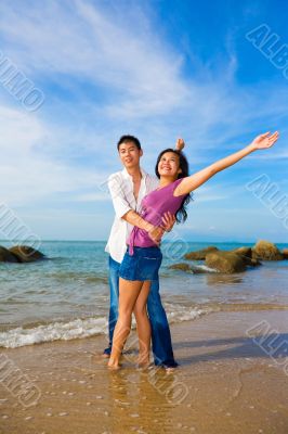 happy loving couple hugging each other on the summer beach