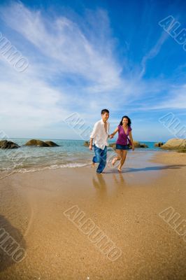 happy young couple running on the beach