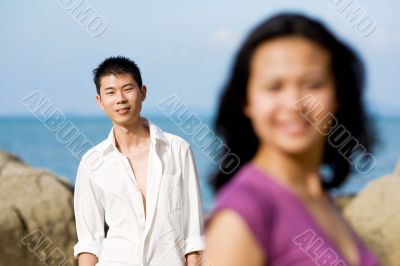 young couple standing by the beach
