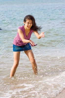 woman having fun splashing water at the seaside