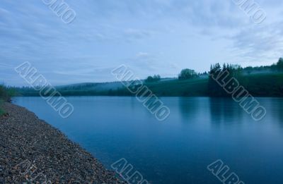 Night summer landscape. Clouds above the river.