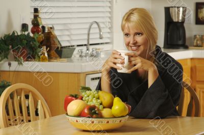 Woman with Cup of Coffee in Kitchen Smiling