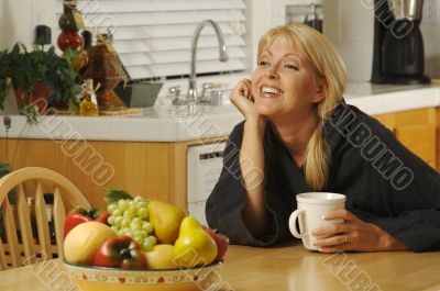 Woman with Cup of Coffee in Kitchen Smiling