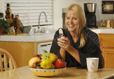 Woman In Kitchen Using Cell Phone