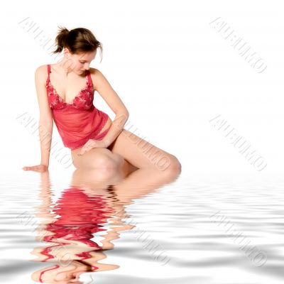 Woman in red lingerie looking down in water
