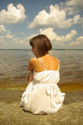 Attractive girl sitting and contemplating aloun