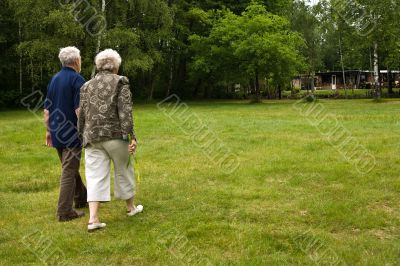 Older couple walking through a park