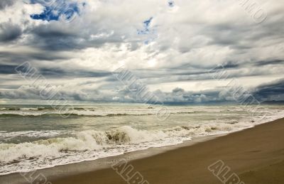 empty beach diring a storm with heavy clouds