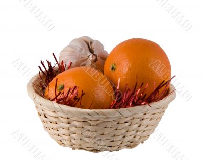Wum basket with two oranges and the head of garlic on a white ba