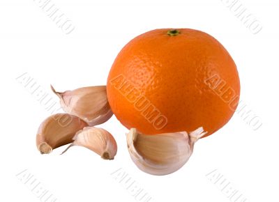 Segments of garlic and a ripe orange on a light background