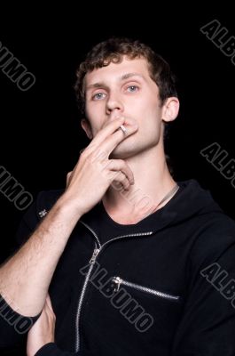 The young man smokes a cigarette. Isolated