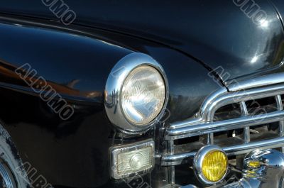 The left headlight of the old automobile