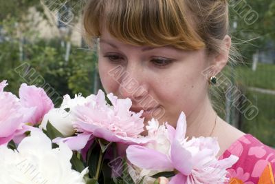 Beautiful young woman holding pink peony