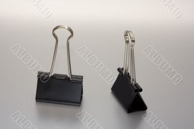 Two paper clip on silver background