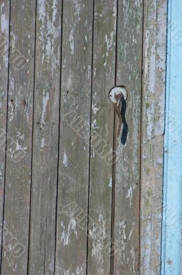  	Aged door handle on wooden entrance door