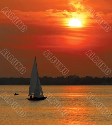 Yacht sailing into sunset