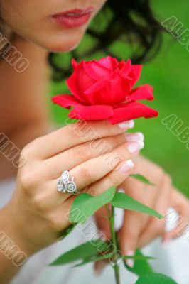 Woman holding single red rose