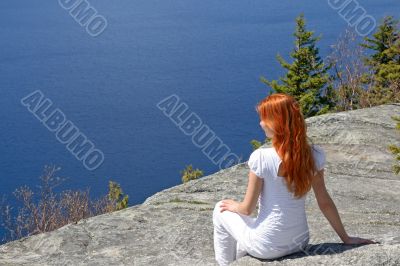 Girl sitting on a rock, enjoying the view