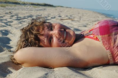 Smiling girl lying on beach