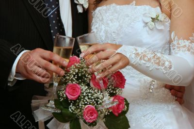 hands of newlyweds with champagne cups
