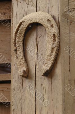  	Vintage horseshoe nailed at old wooden wall