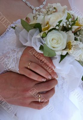hands of newlyweds with bouquet