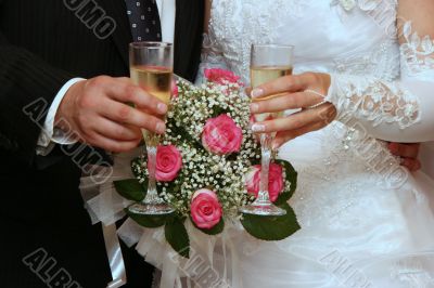 hands of newlyweds with champagne cups