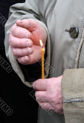 Flaming candle upon palms protection