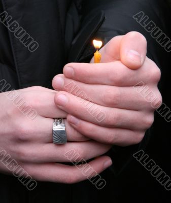 Flaming candle upon palms protection