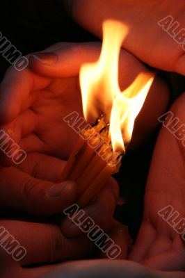 Flaming candle upon palms protection