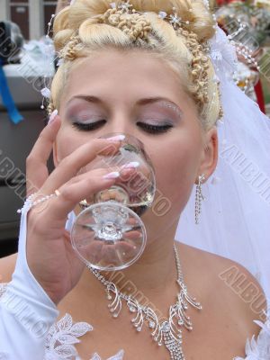 Young bride drinking champagne