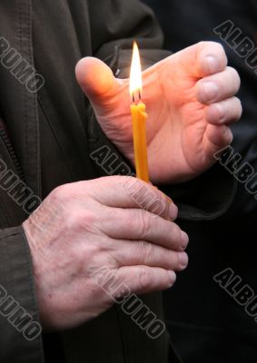Flaming candle upon palms protection